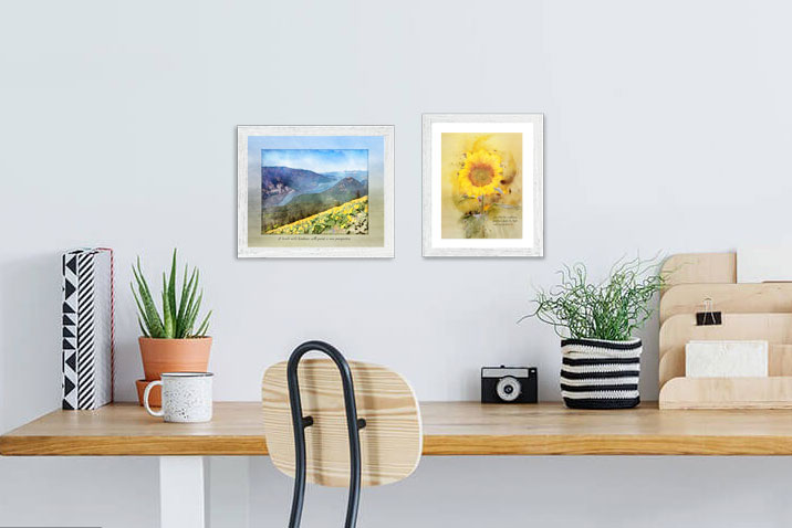 Kindness Roots "Art of Gratitude" Prints of a sunflower and river view are framed and displayed over a desk.